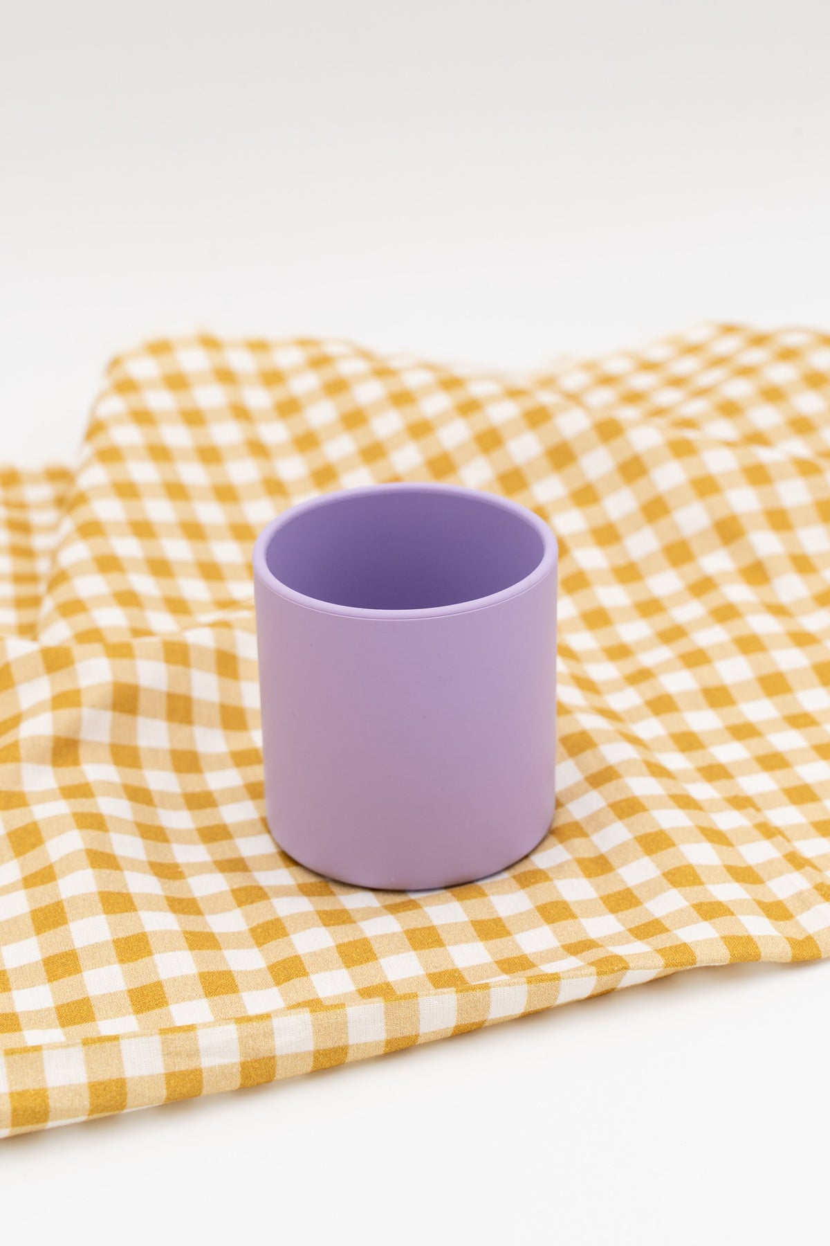 One open lilac cup on checked fabric